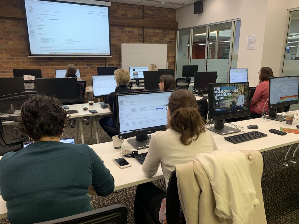Students working at computers in a university library study room