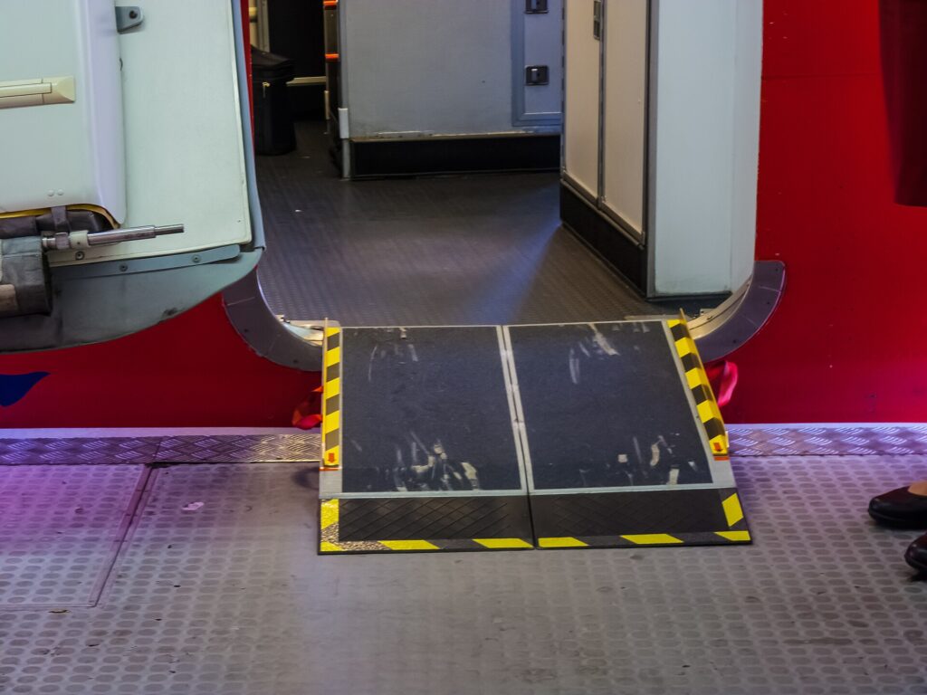 A boarding ramp with yellow and black edges bridging the gap into an aircraft door