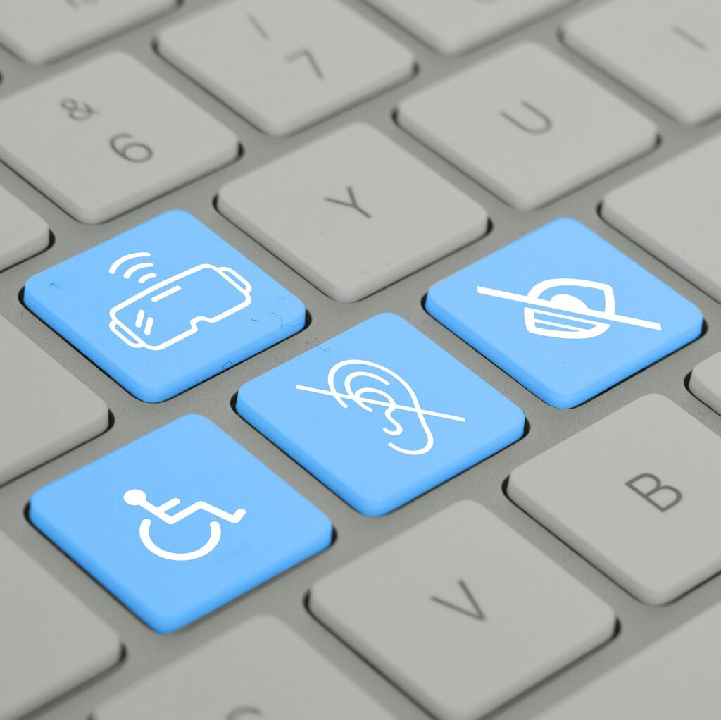 A computer keyboard with blue keys showing accessibility symbols