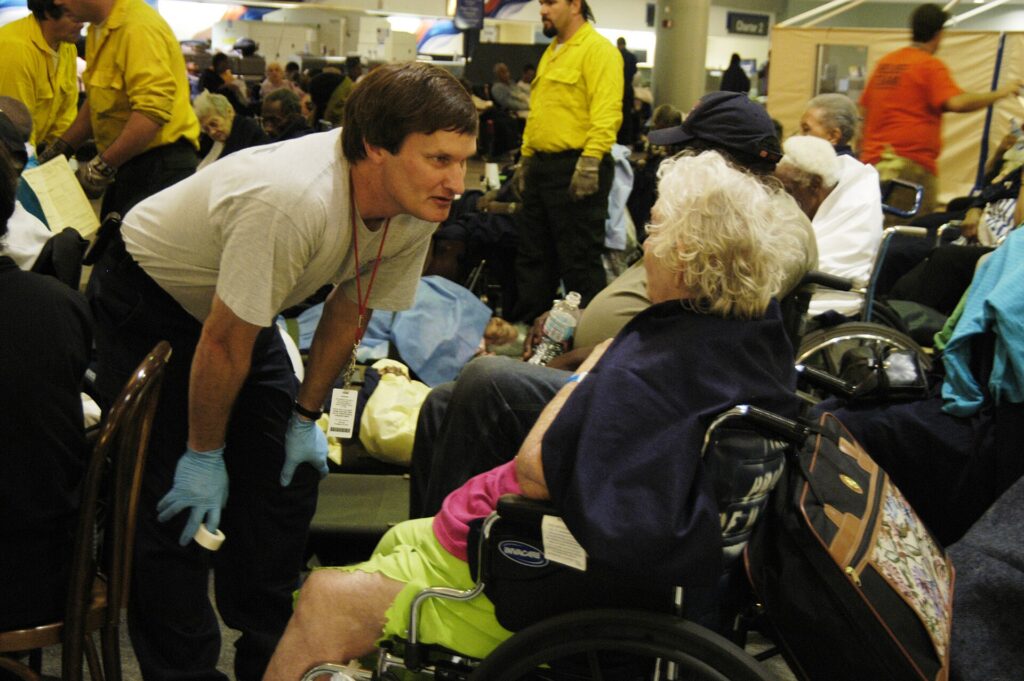 Airport assistance staff helping passengers in wheelchairs in a busy terminal