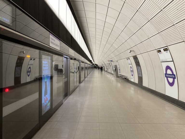 A long, level Elizabeth line platform at Farringdon with glass screen doors along the edge