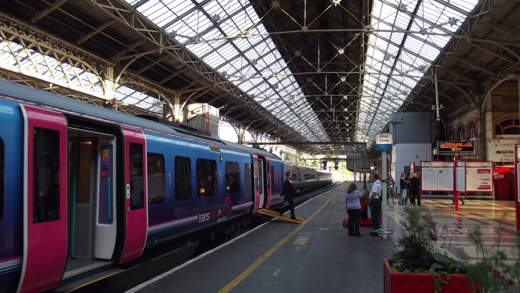 A train waiting at a platform under a large station canopy