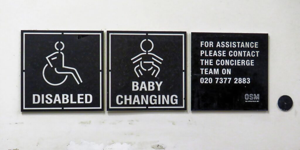 Toilet door signs for Disabled and Baby Changing with a number to call for assistance