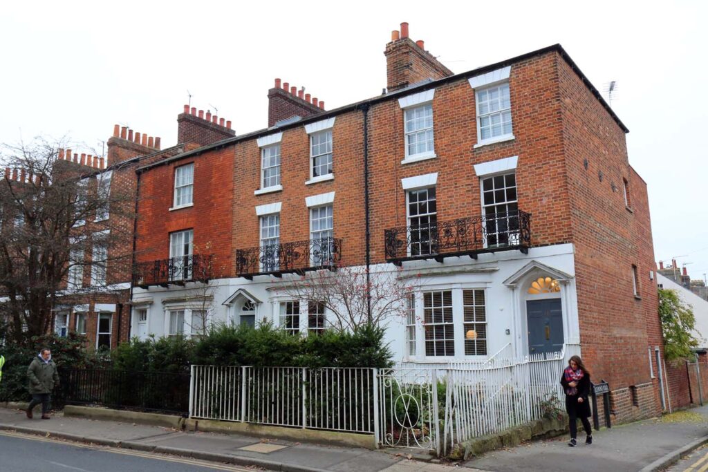 A row of brick terraced houses with steps up to their front doors